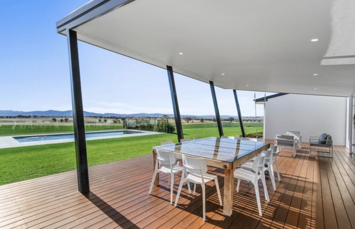 Luxury architects and master builders collaborating over detailed custom home blueprints in a sophisticated design studio with warm natural lighting and refined finishes