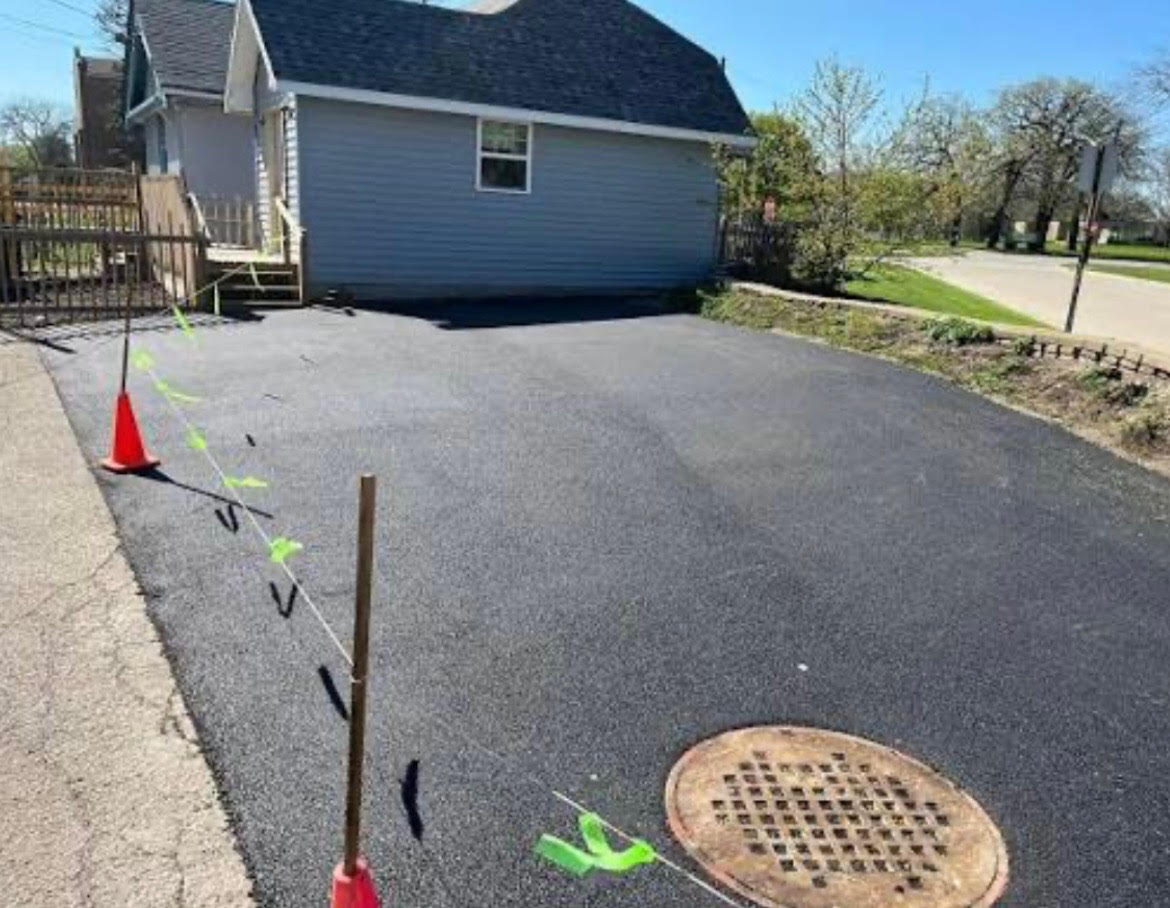 Freshly resurfaced smooth black asphalt driveway with clean edges in Maine