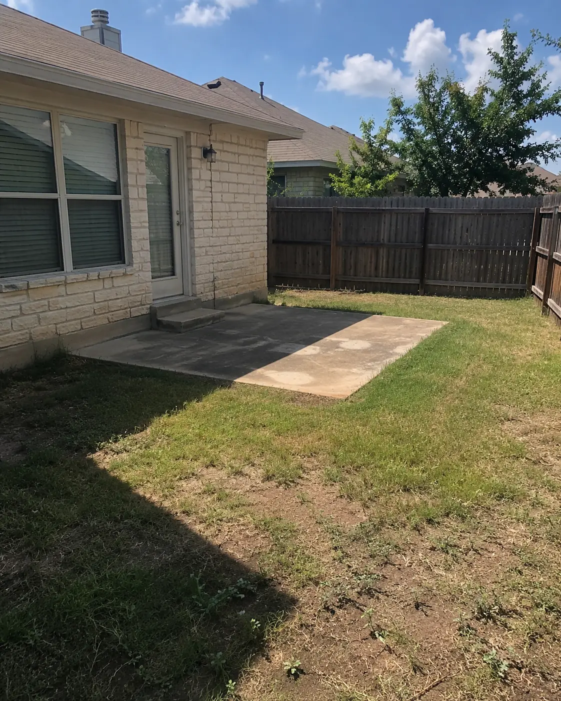 Backyard before landscaping work with plain open space