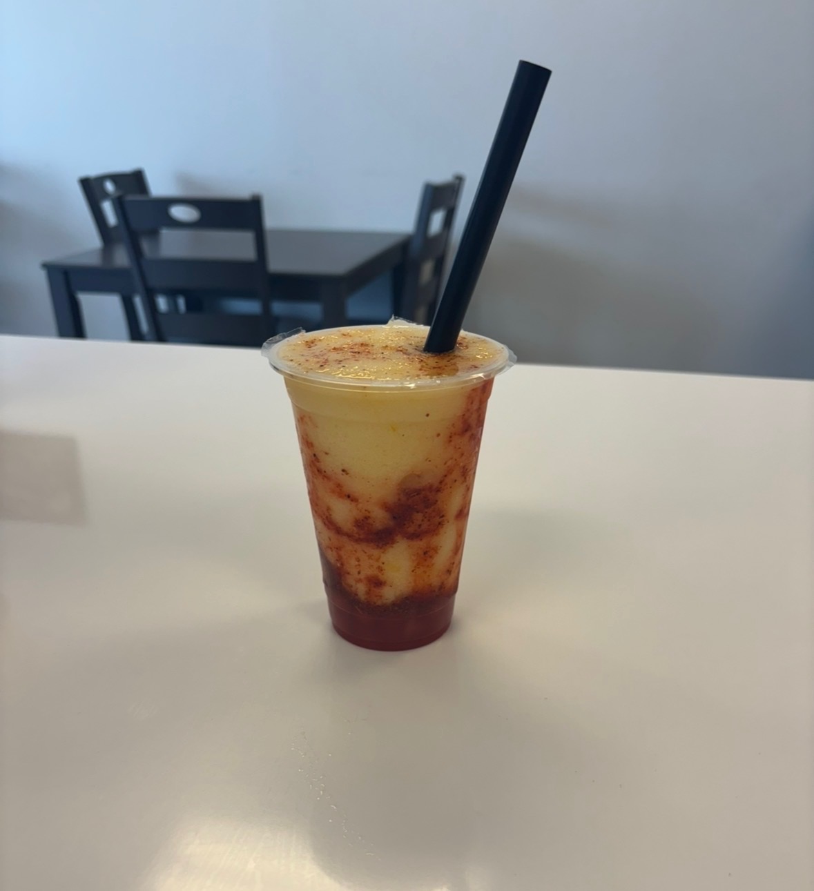 Bright green kiwi honeydew fruit refresher with boba pearls on a rustic wooden counter in Bloomfield New Mexico