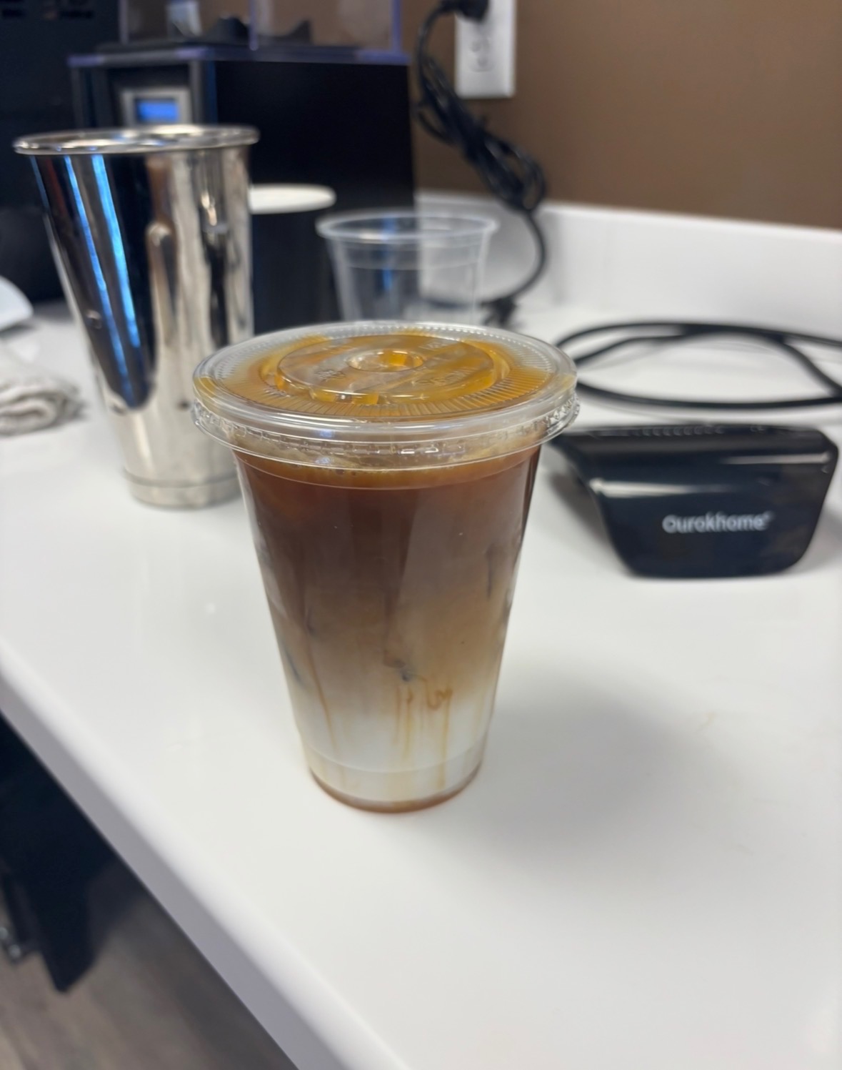 Layered iced brown sugar milk tea with chewy tapioca boba pearls served in a tall glass on a rustic wooden coffee shop counter at Jayweezys