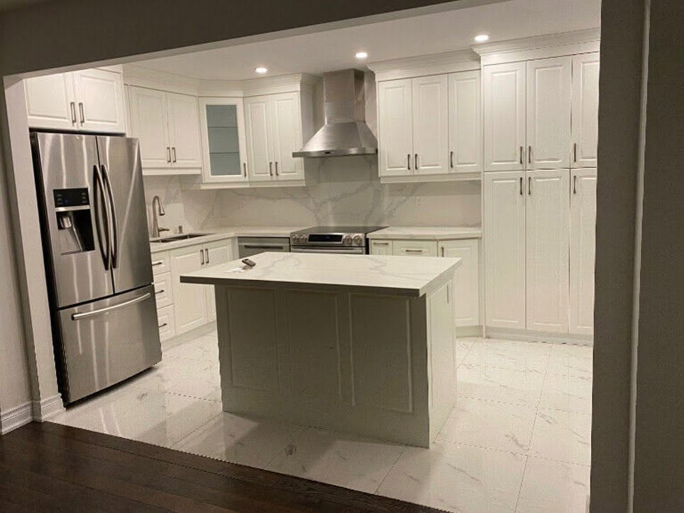 Custom kitchen renovation with white cabinetry, marble countertops, and center island