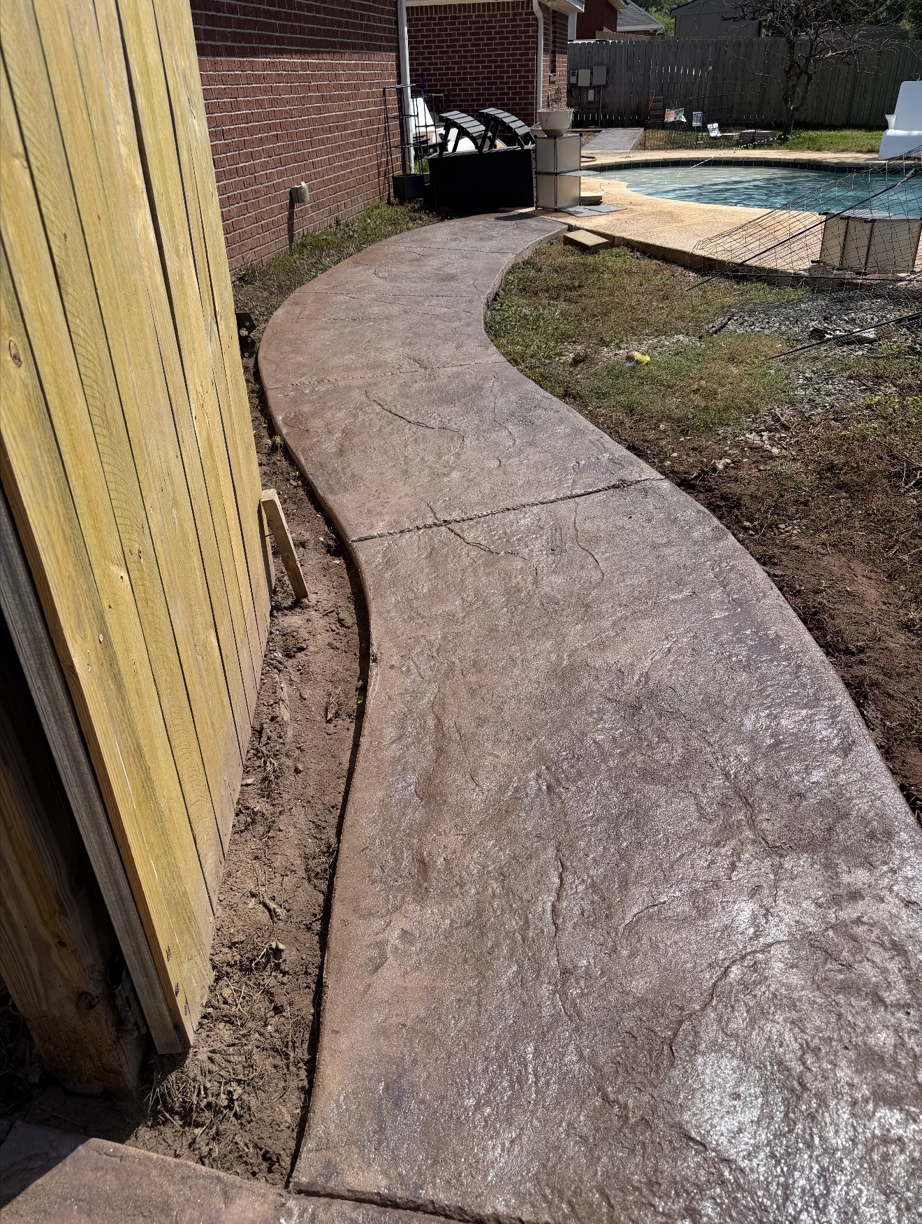 Sleek modern broom-finished concrete driveway leading to a contemporary home