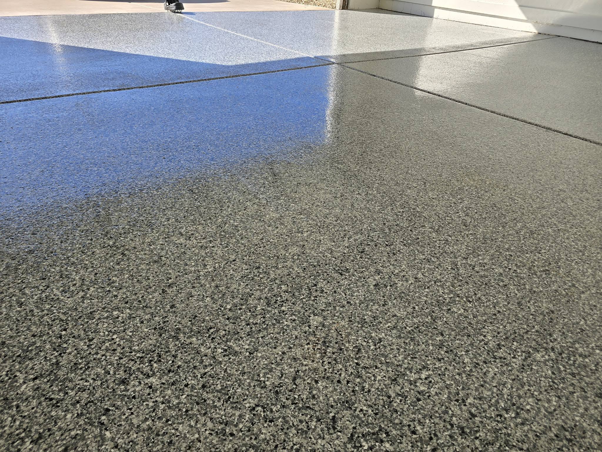 Glossy epoxy floor coating application in a modern garage showing seamless durable finish