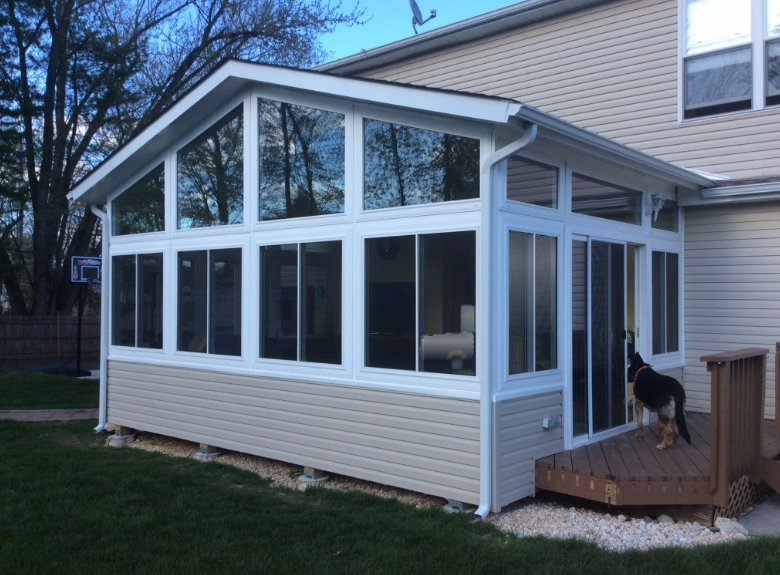 Team of Amish builders constructing the frame of a modern home addition