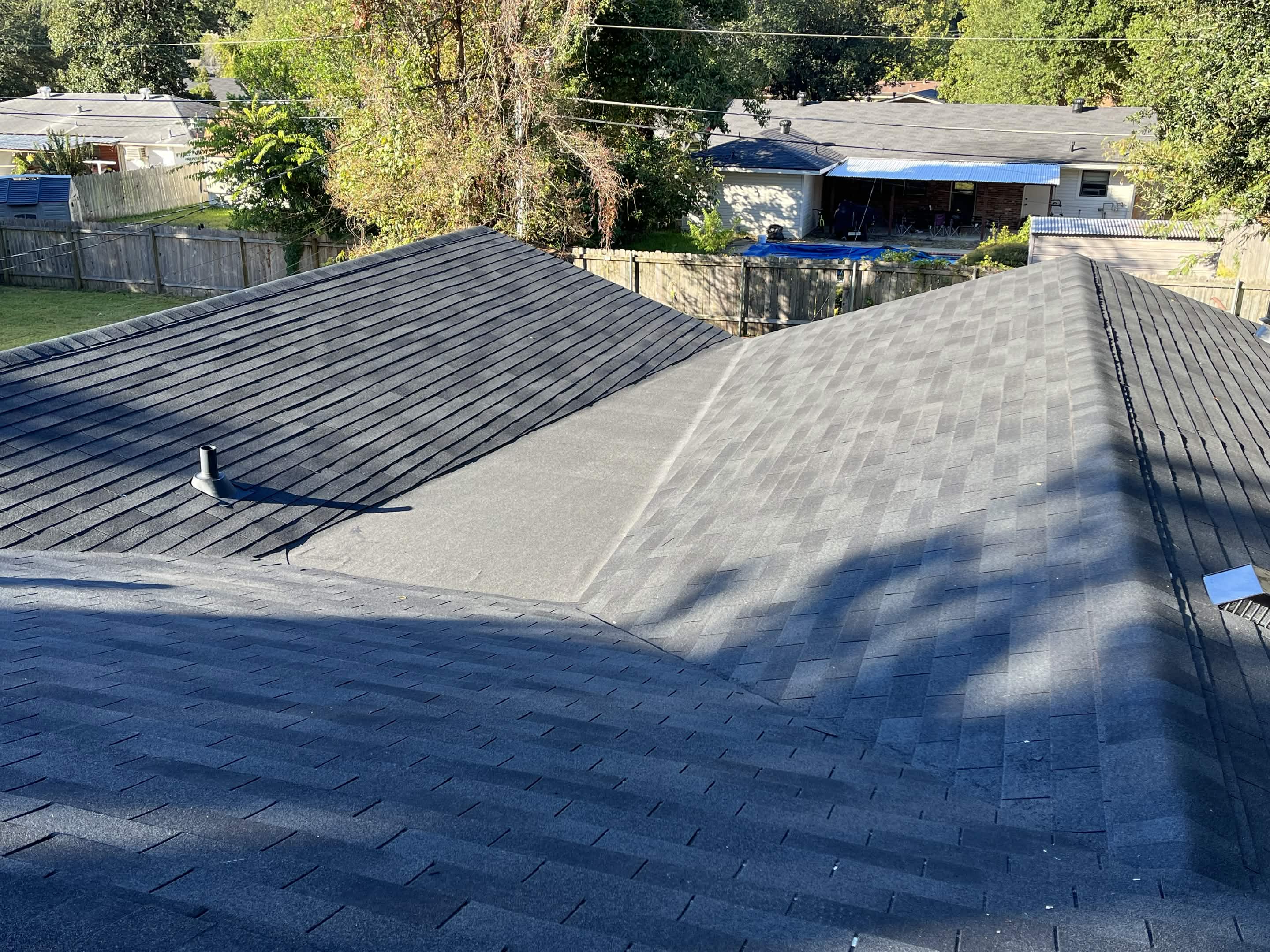 Finished Roof on suburban home with clean ridge cap and dark gray shingles