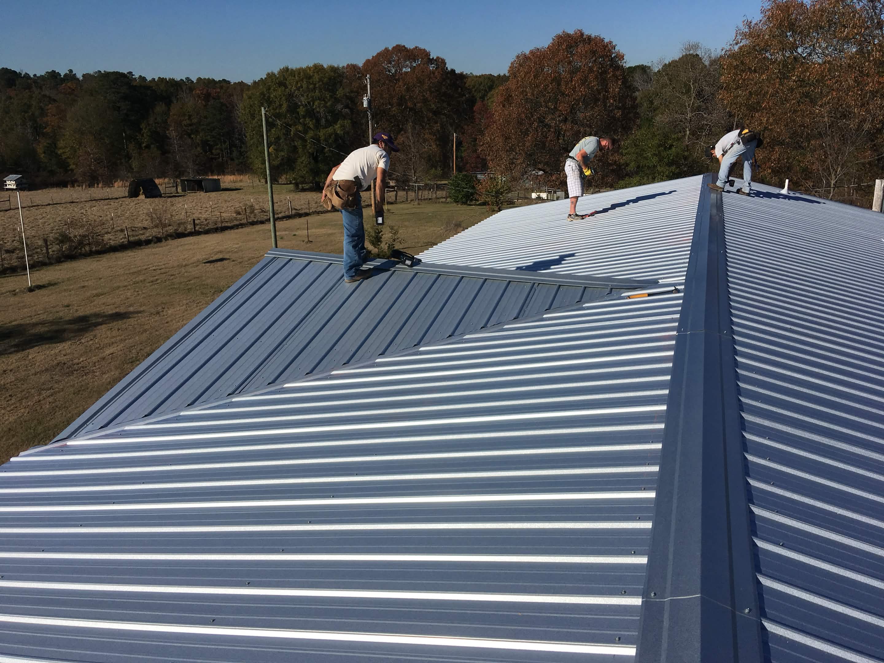 Brown Home Improvement crew tearing off old shingles and preparing roof deck for new installation