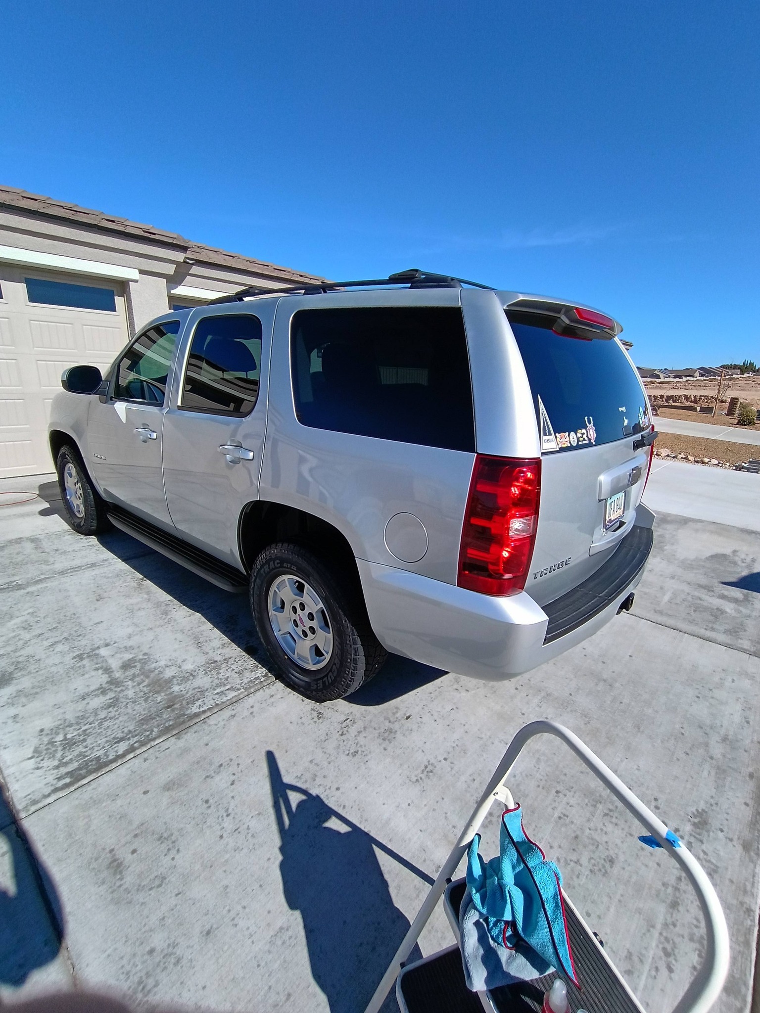 A professional detailer polishing the hood of a luxury car.