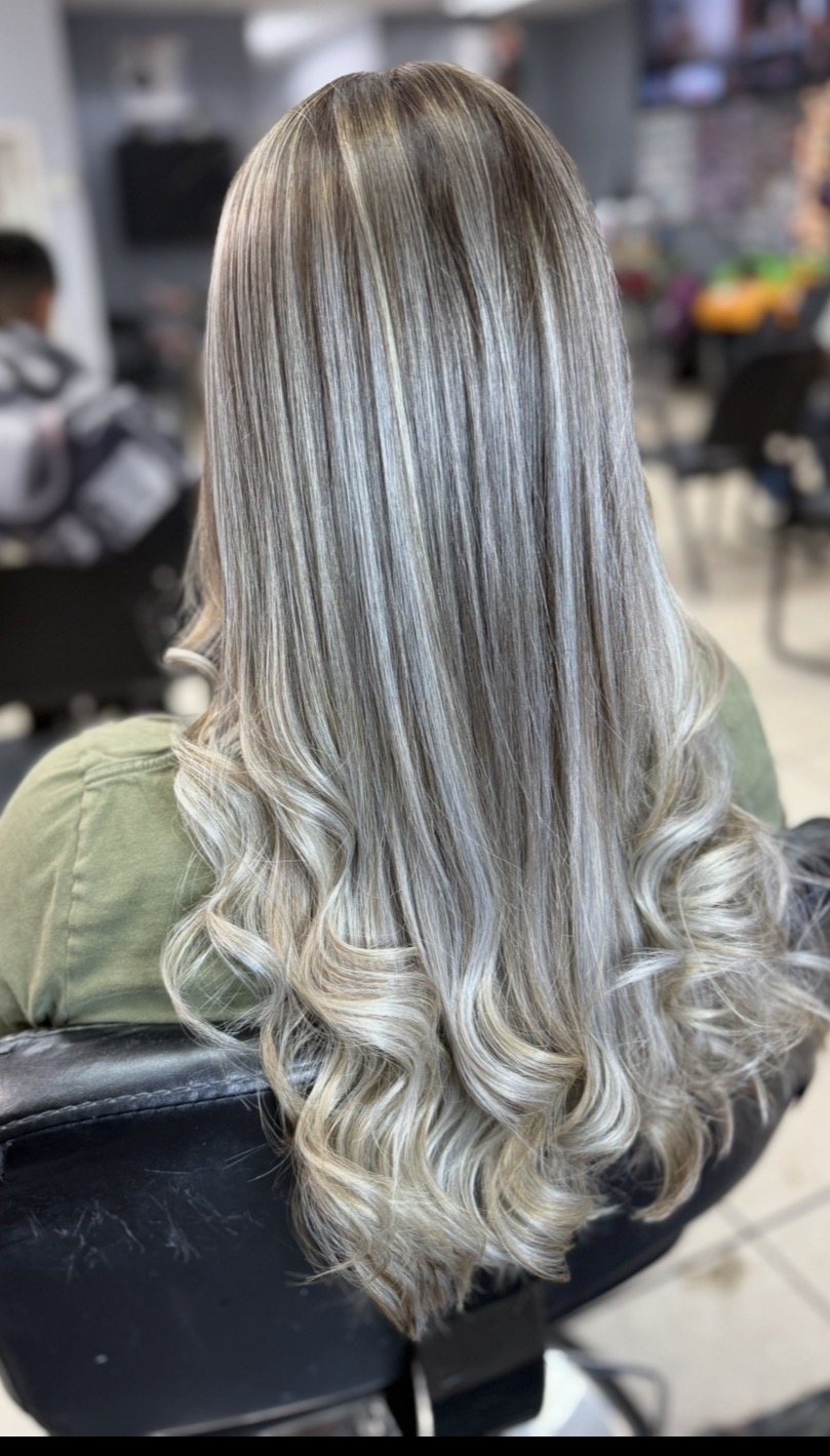 Friendly bilingual female stylist at KARY HAIR SALON in Conroe styling a happy client's hair in a warm, welcoming family beauty salon