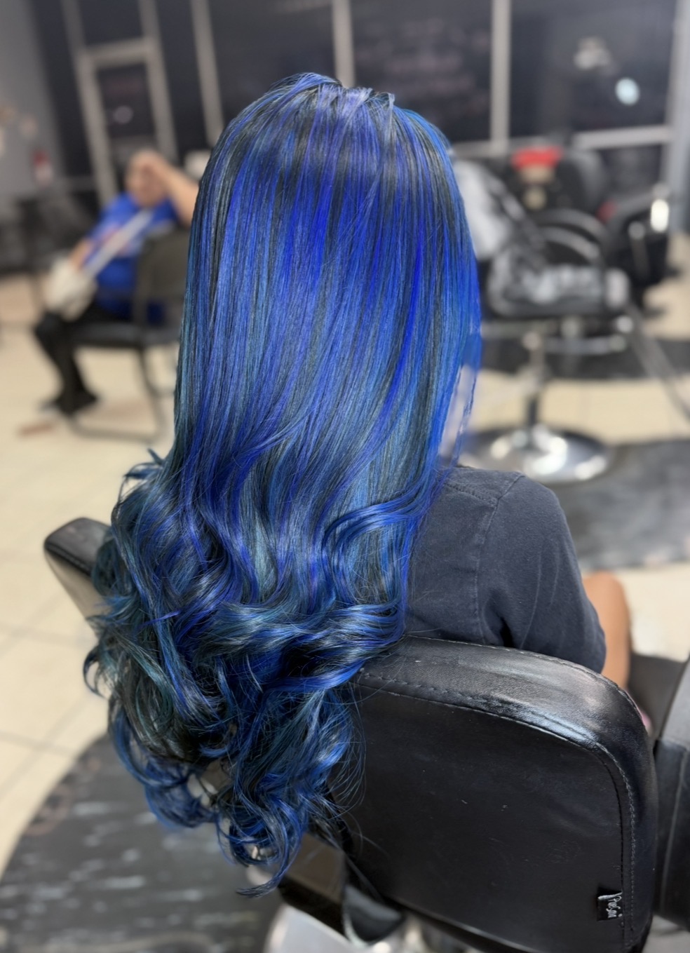 Authentic interior photo of KARY HAIR SALON in Conroe Texas showing real styling stations, mirrors, salon chairs, product shelves and warm inviting bilingual family atmosphere