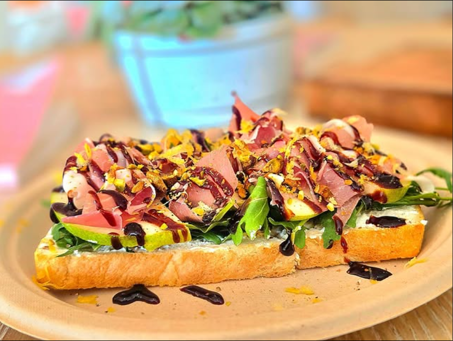Artisan avocado toast on sourdough bread with a fresh cold-pressed green juice