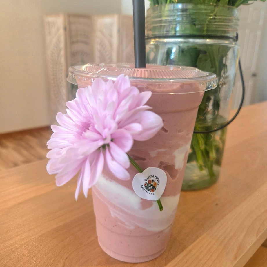 Artisan specialty latte in a ceramic cup with intricate foam art on a rustic wooden table