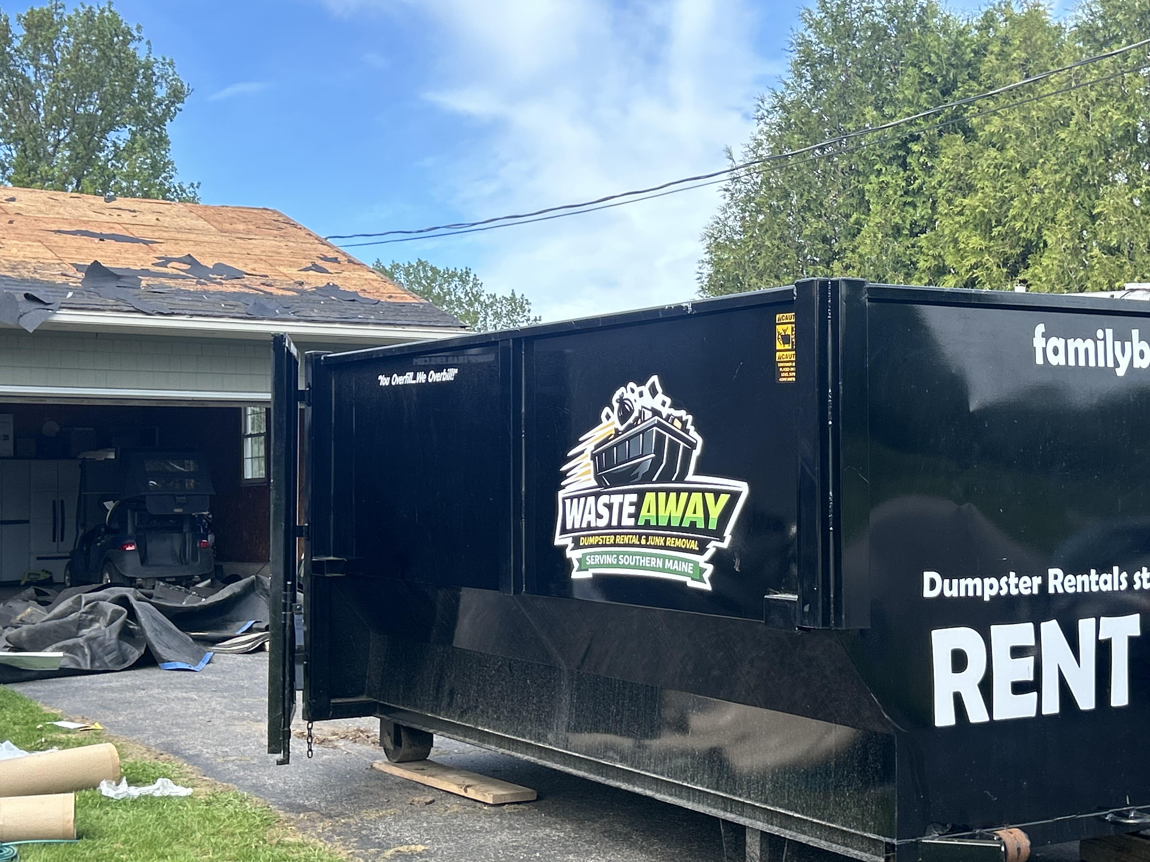 16-yard roll-off dumpster parked in a residential driveway in Maine ready for cleanout