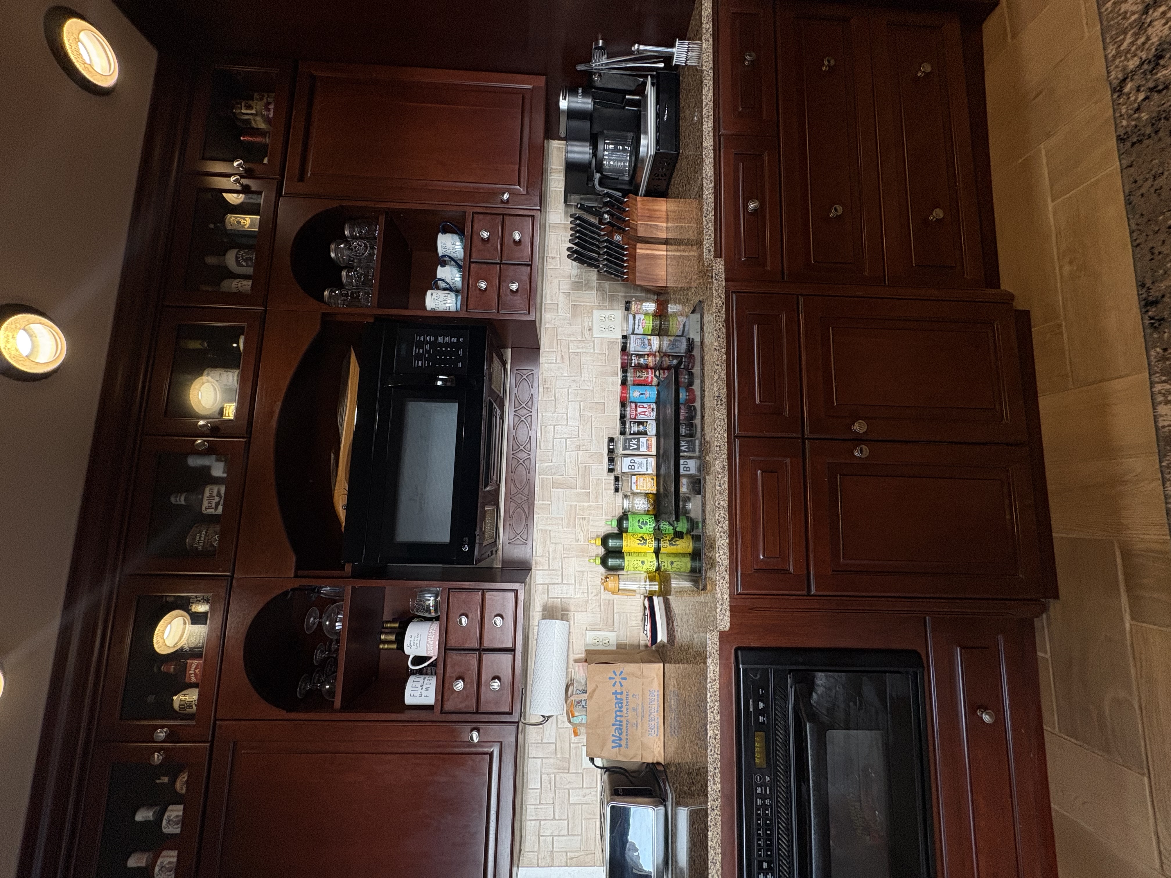Sunlit freshly cleaned kitchen with white cabinets, sparkling countertops, and a vase of fresh wildflowers