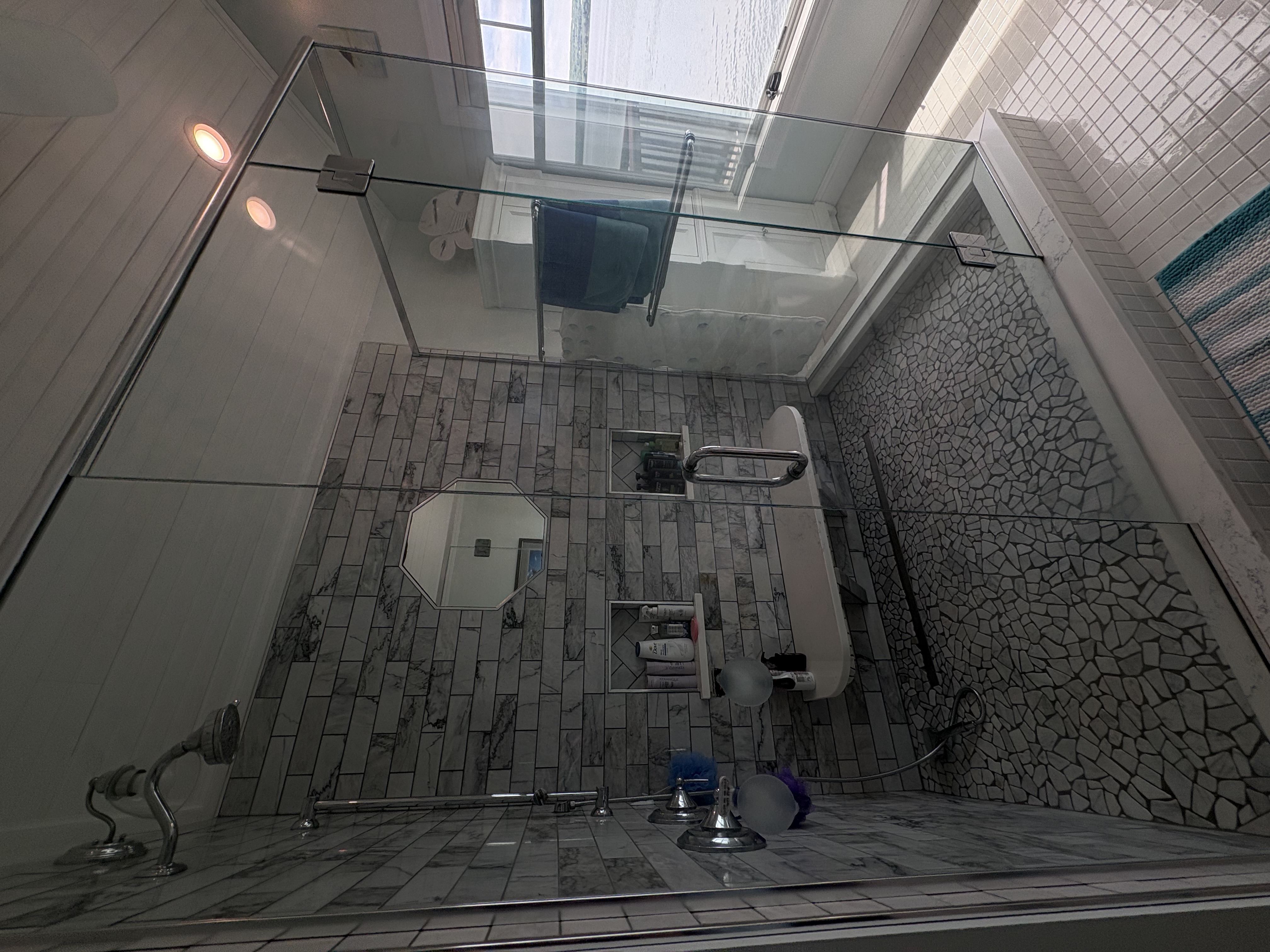 Sparkling white bathroom with polished chrome fixtures, neatly folded fresh towels, and a small bundle of eucalyptus