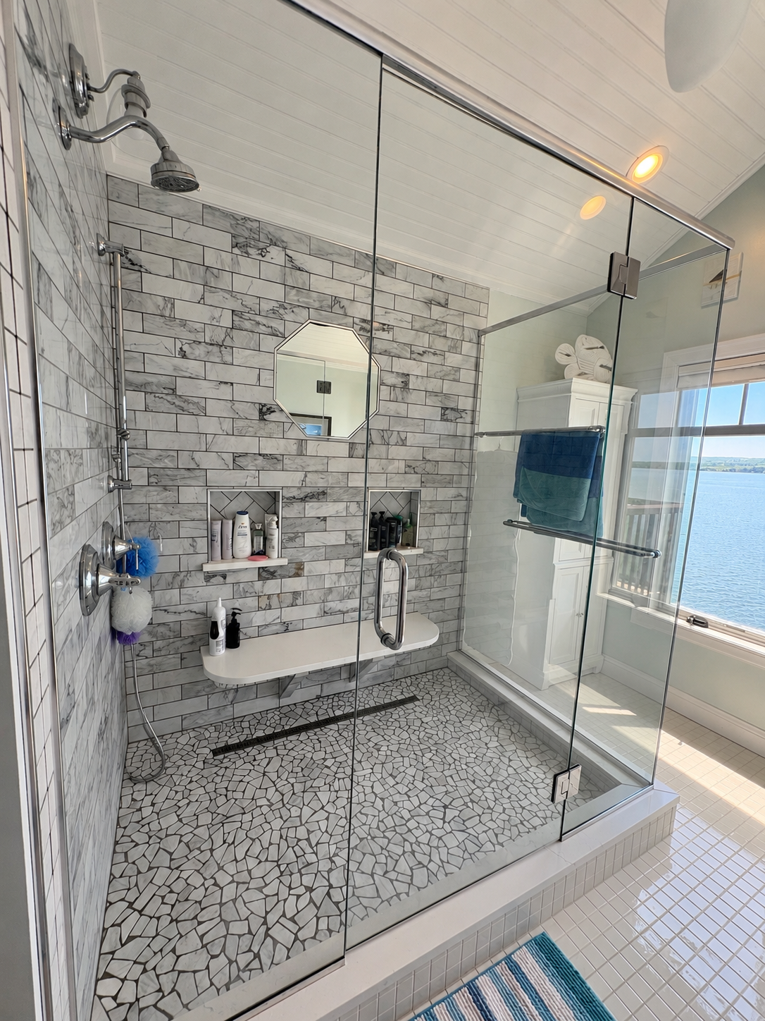 Sparkling white bathroom with polished chrome fixtures, neatly folded fresh towels, and a small bundle of eucalyptus