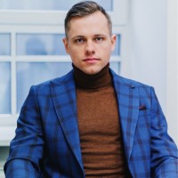 Professional headshot of Nils Jasevics, founder of StreamerCapital, in a modern tech office setting
