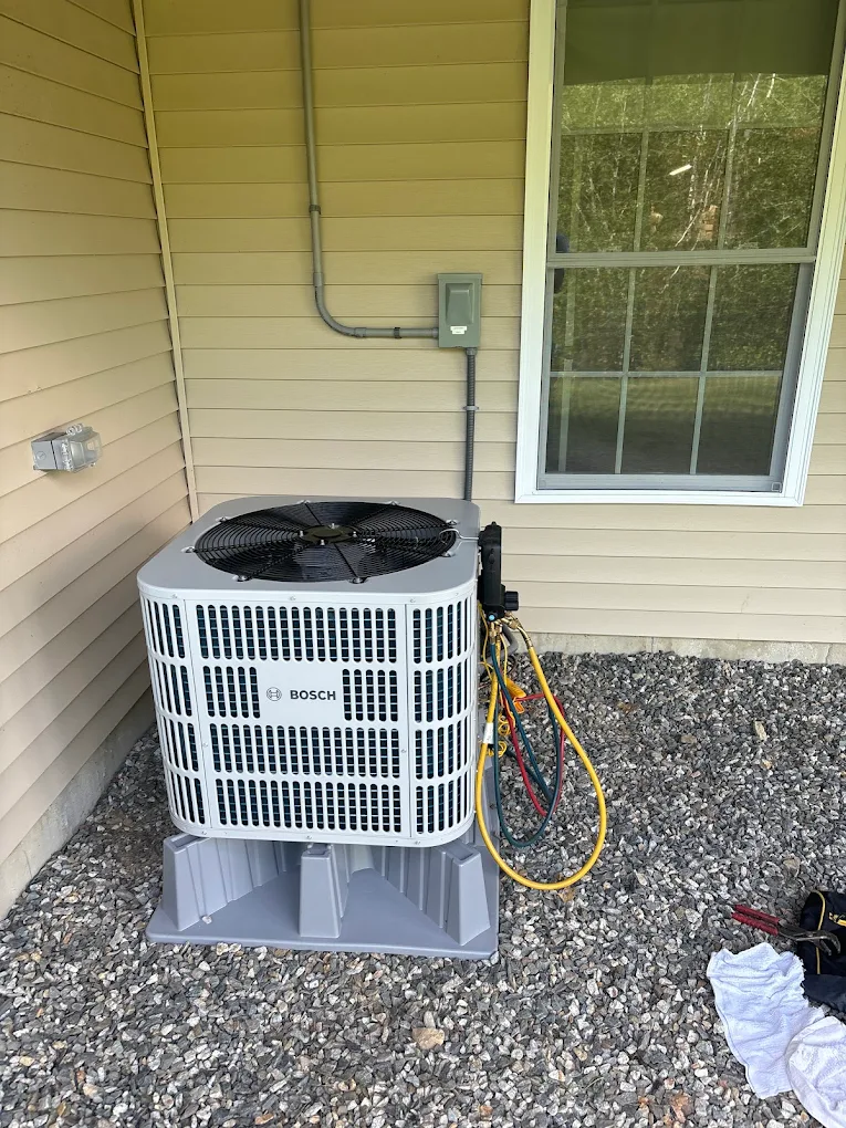 Professional HVAC technician installing a modern Samsung heating and cooling system in a New Hampshire home