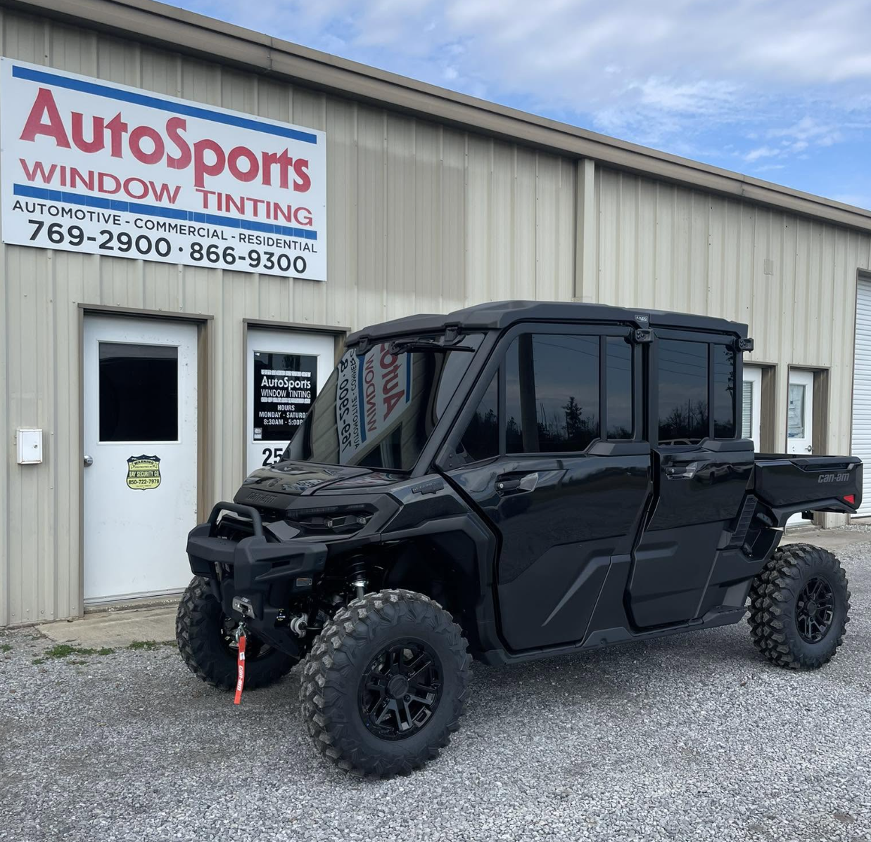 Black pickup truck with full window tint installation parked outside professional automotive shop