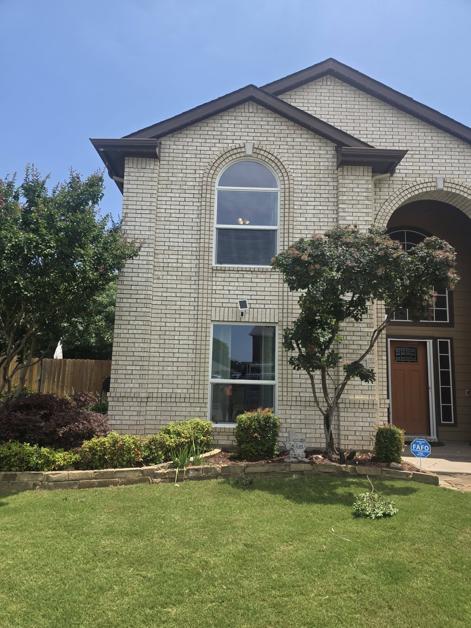A professional from Montgomery Glass LLC carefully installing a large custom glass panel in a modern Dallas home.