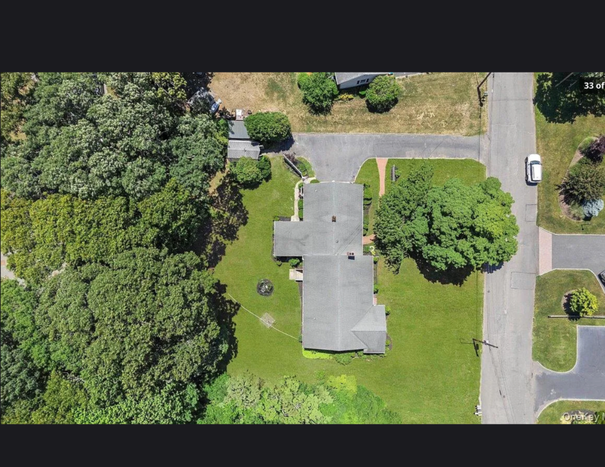 Exterior of 870 Crittens Lane in Southold, NY — a classic 1954-built single family residence set on a 0.51-acre lot with mature landscaping on Long Island's North Fork