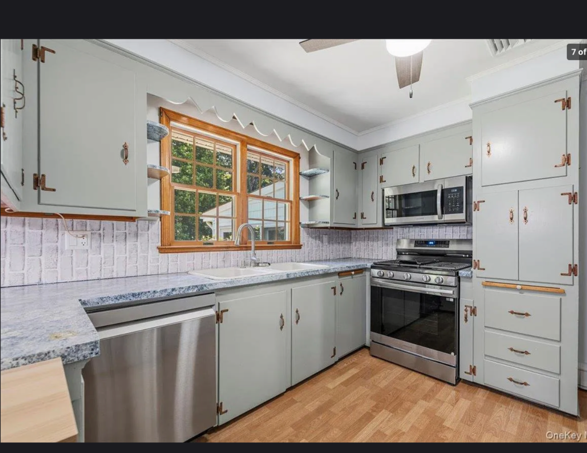 Bright, functional kitchen at 870 Crittens Lane in Southold featuring classic white cabinetry, ample counter space, and warm natural light — perfect for everyday North Fork living