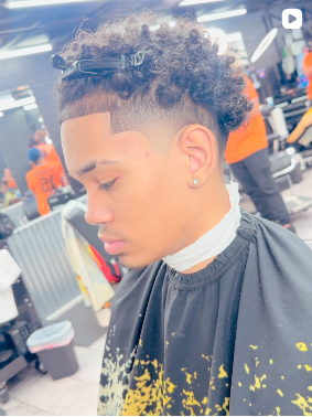 A young boy smiling in the barber chair, happy with his new haircut