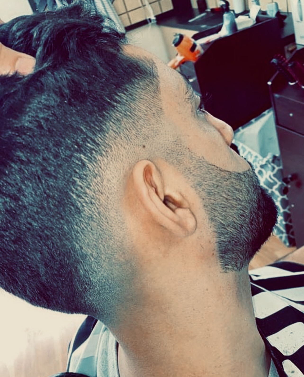 Barber styling a client's hair with product