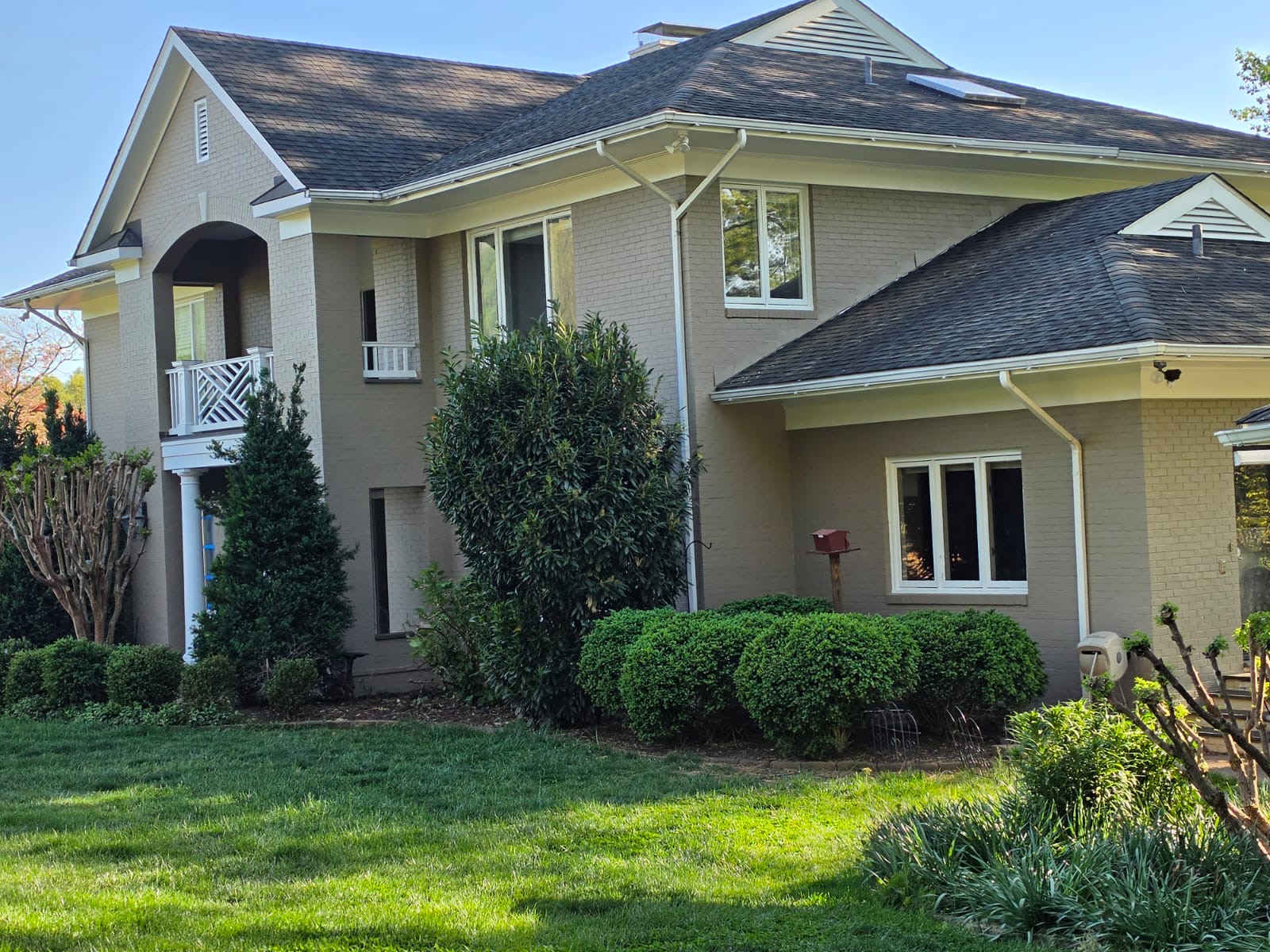 Professional painting contractor from K&J Pro Painting applying a fresh coat to a modern home exterior