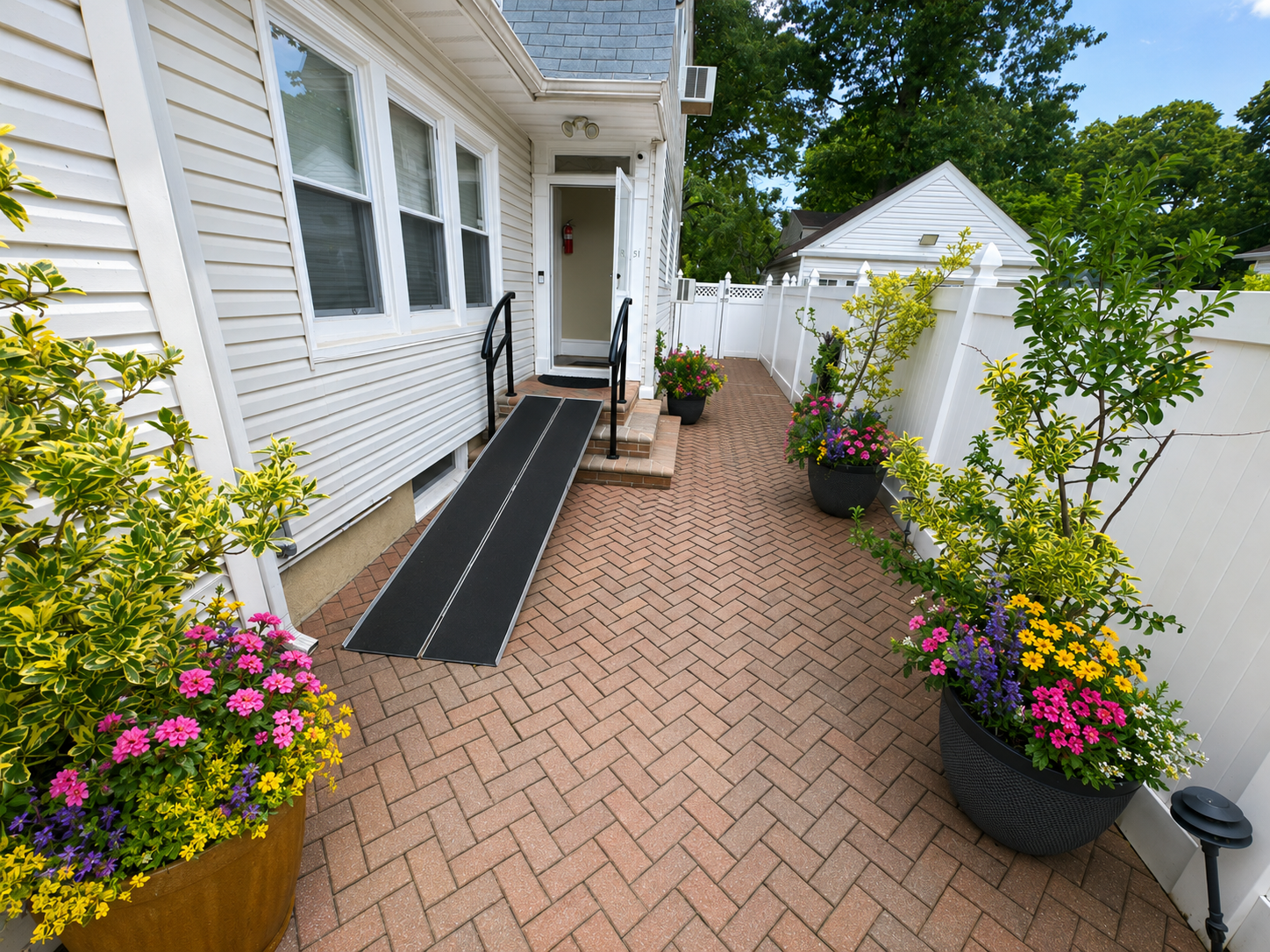 Diverse multicultural seniors of various ethnicities including African American, Asian, Hispanic/Latino, South Asian, Middle Eastern, and White seniors walking together on the serene landscaped garden path with benches at Amity Springs