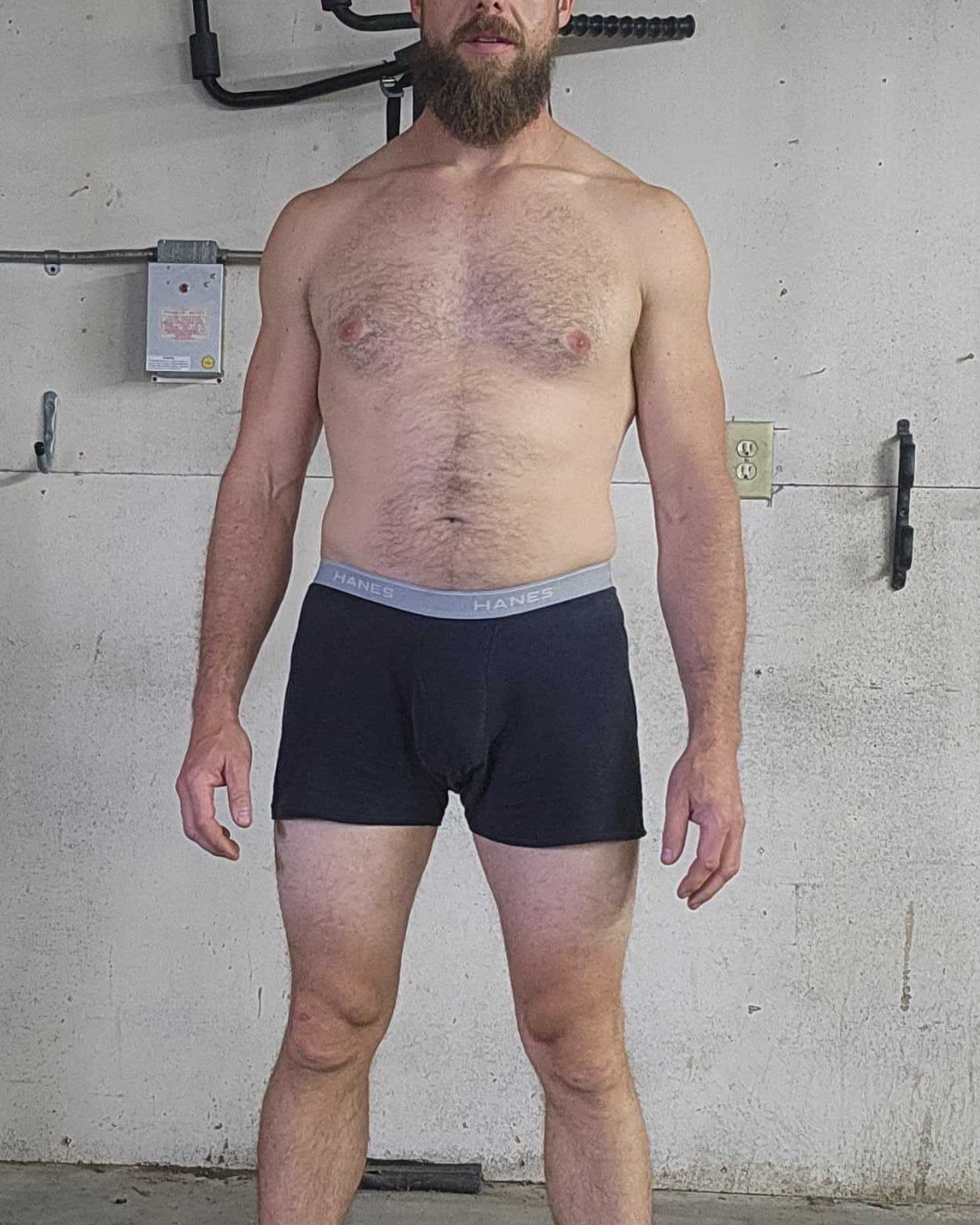 Before transformation photo of male competitor Kyle at week one showing higher body fat percentage and untrained physique