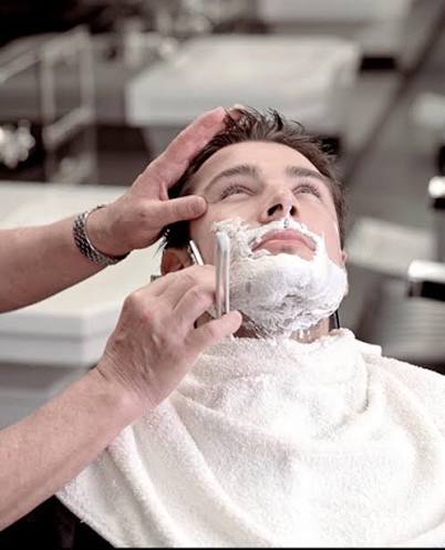 Traditional Turkish hot towel shave with straight razor and steaming towels in premium barbershop