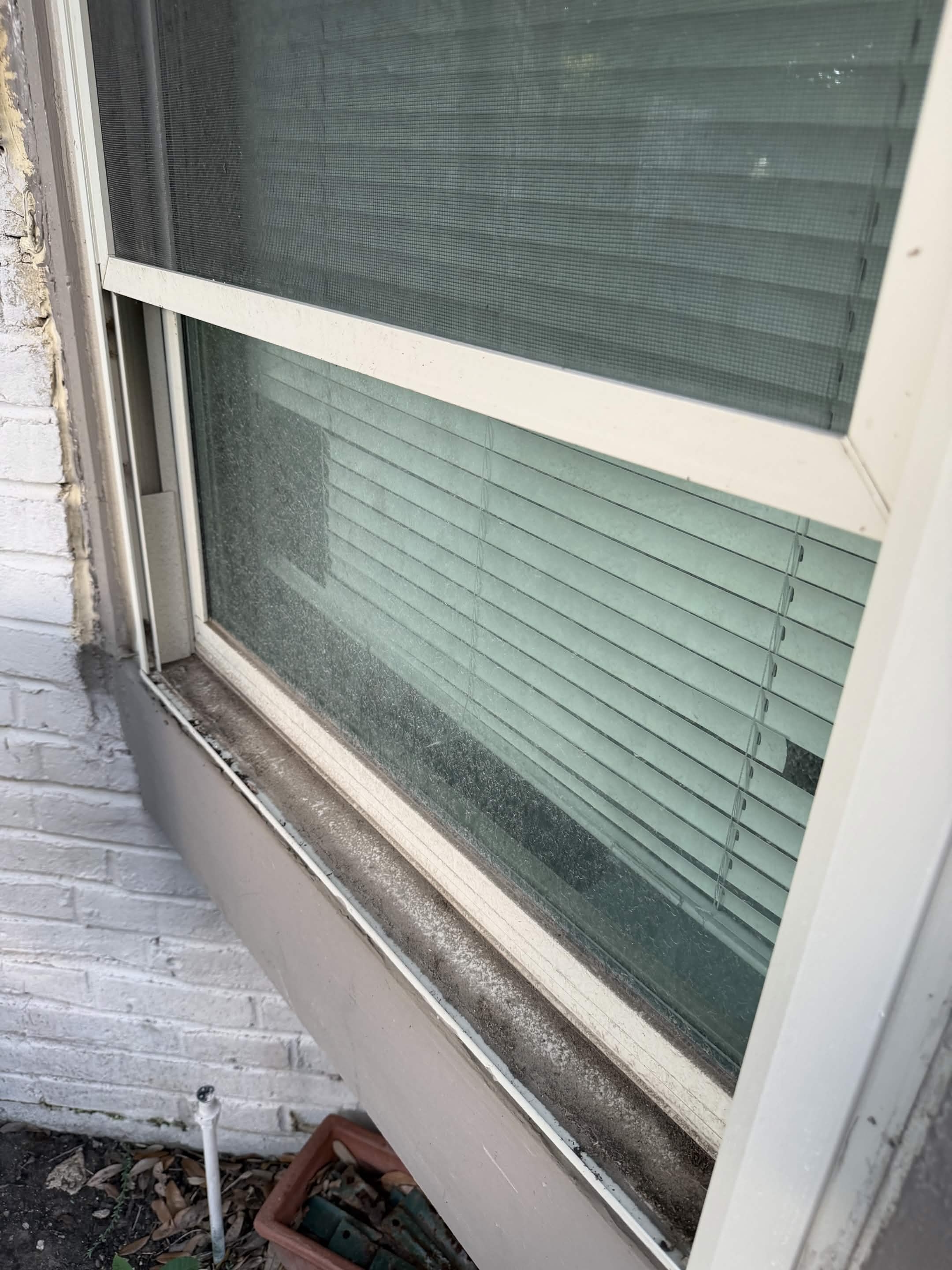 Dirty streaky window covered in grime and water spots before professional cleaning