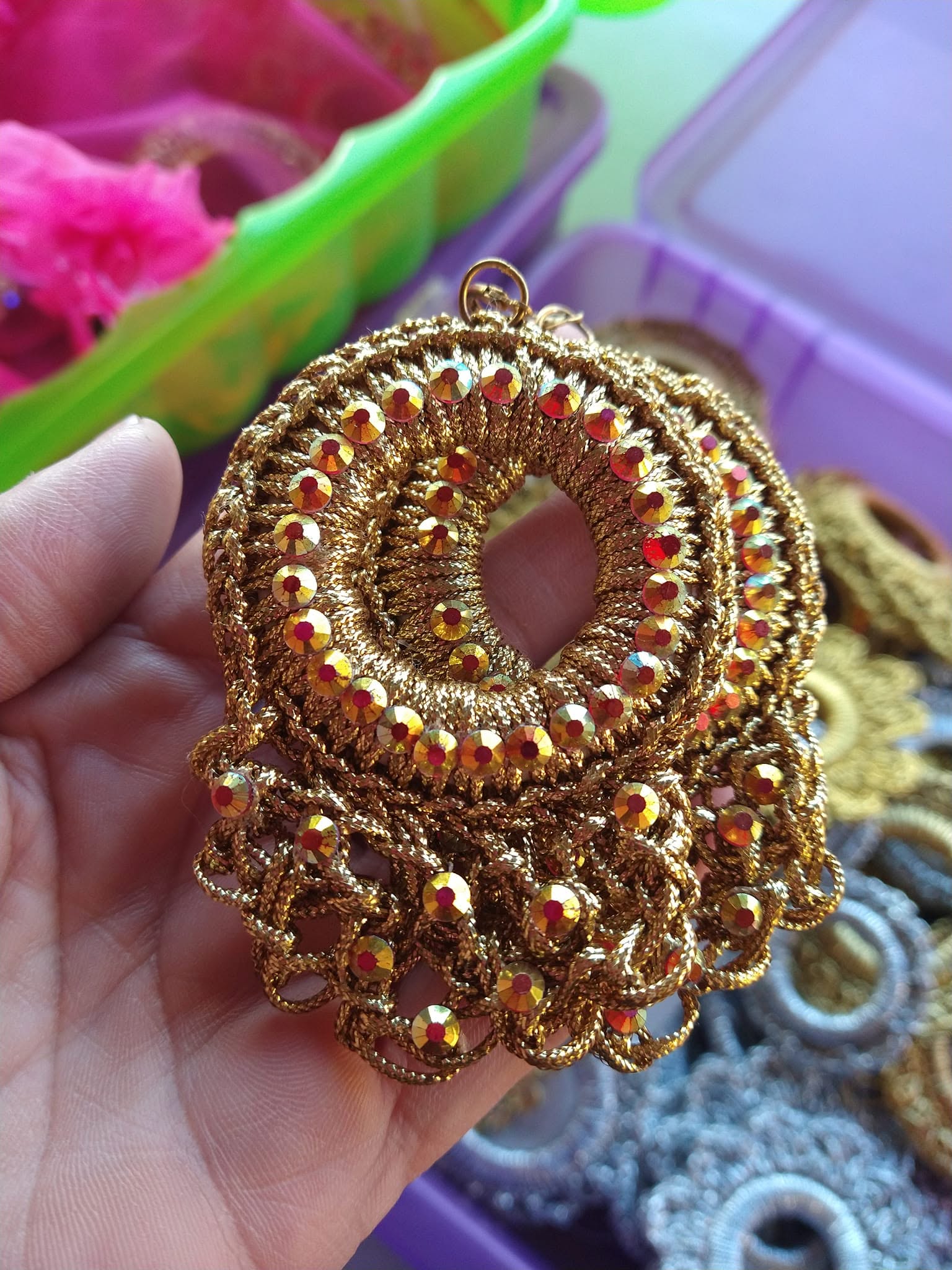 Hand-knitted folklorico earrings in a traditional floral pattern against a dark background
