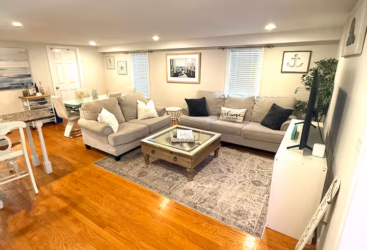 PLACEHOLDER - Replace with your actual photo: Cozy living area at The W at Wildemere Beach featuring sectional sofa, fireplace, and coastal decor