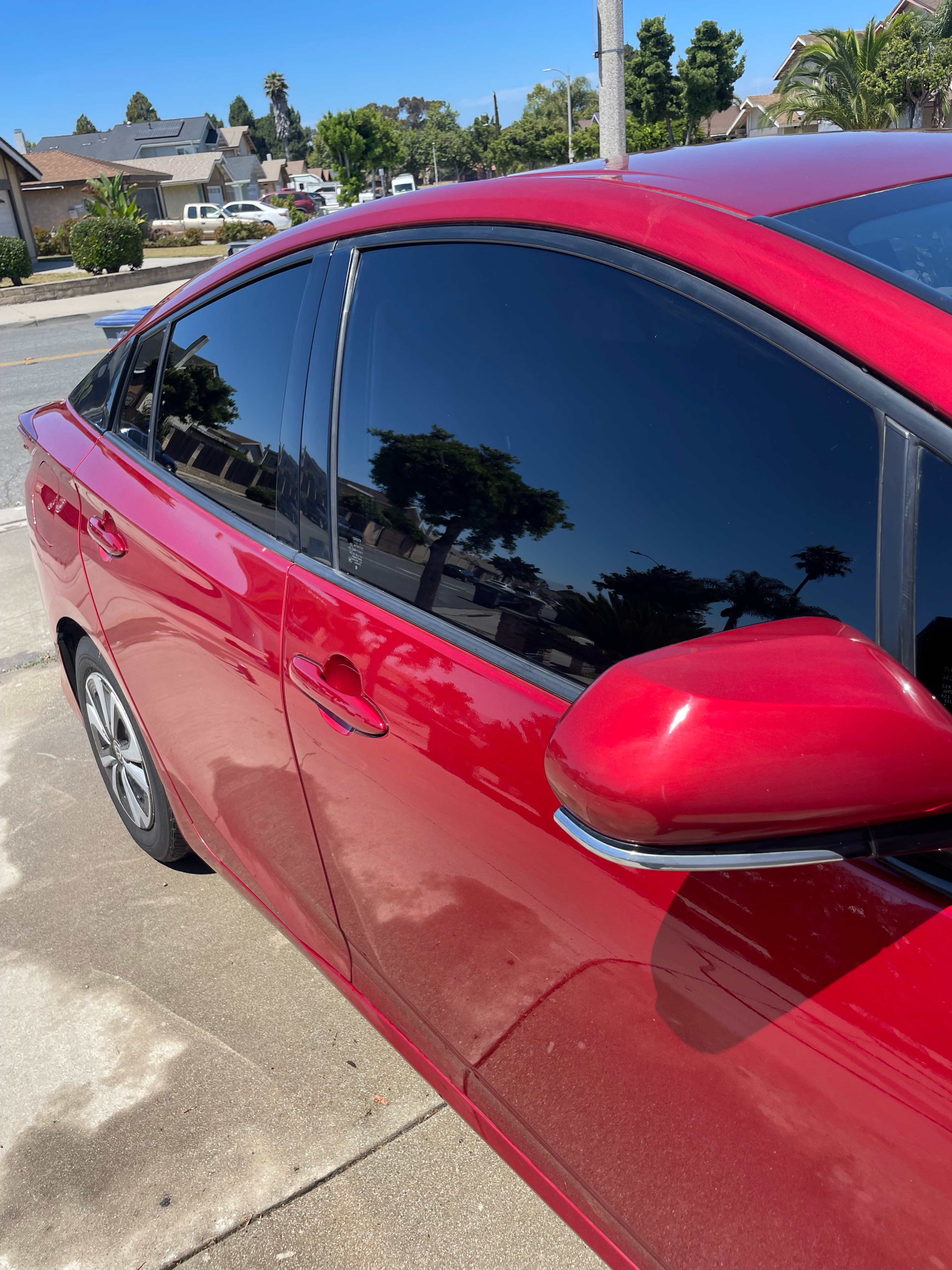 Flawless mirror-like reflection of clouds on a freshly detailed black SUV side panel