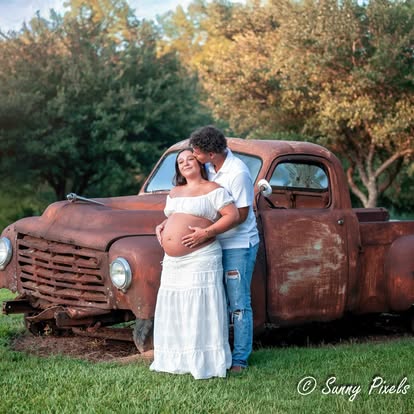 Beautiful expectant mother in a flowing dress during a golden hour maternity photoshoot