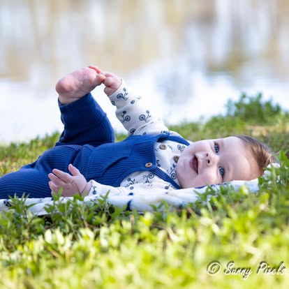 Sunlit newborn baby portrait wrapped in soft cream blanket during a natural light studio session