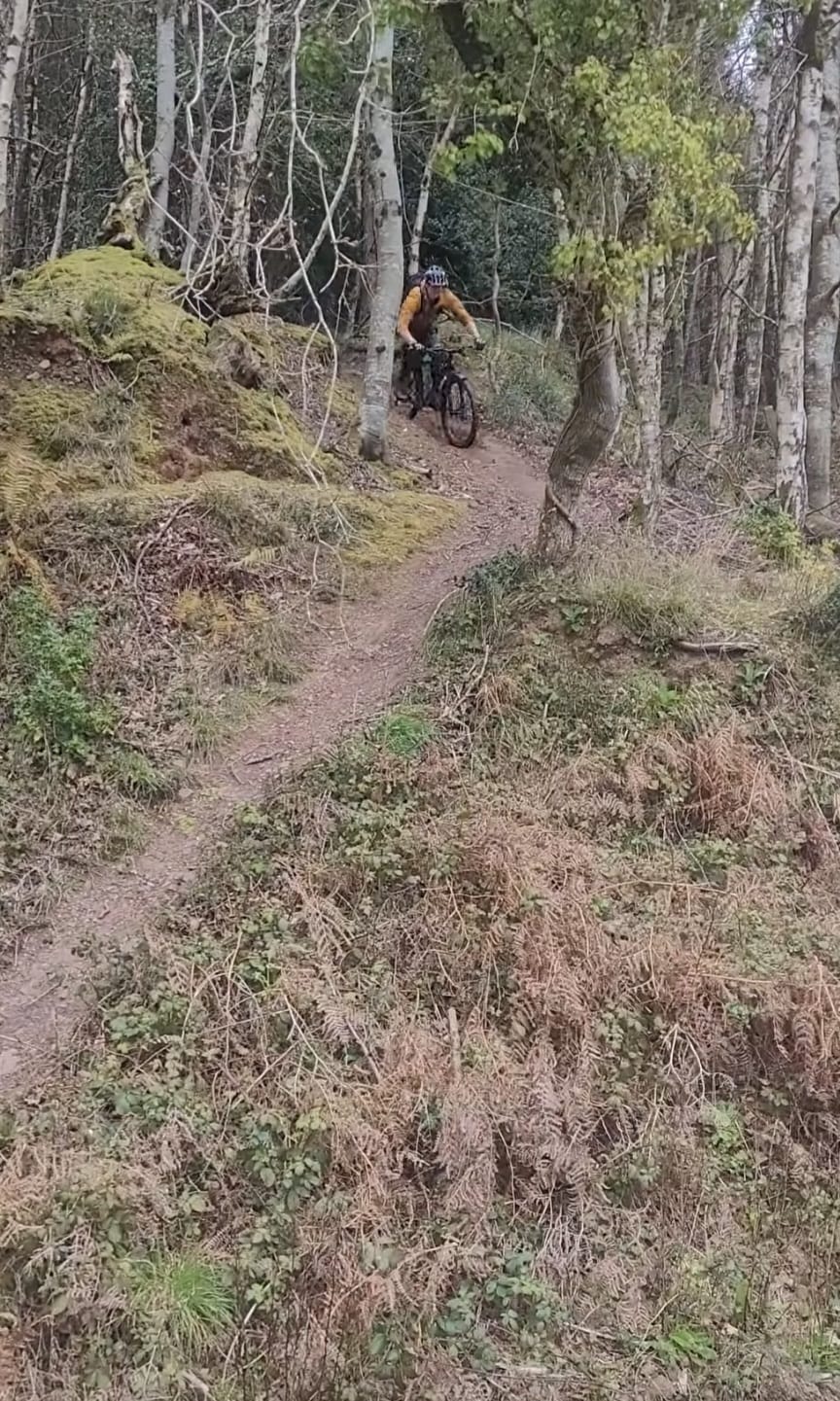 Mountain biker Peter standing with his bike on a dramatic, misty Exmoor trail at sunrise