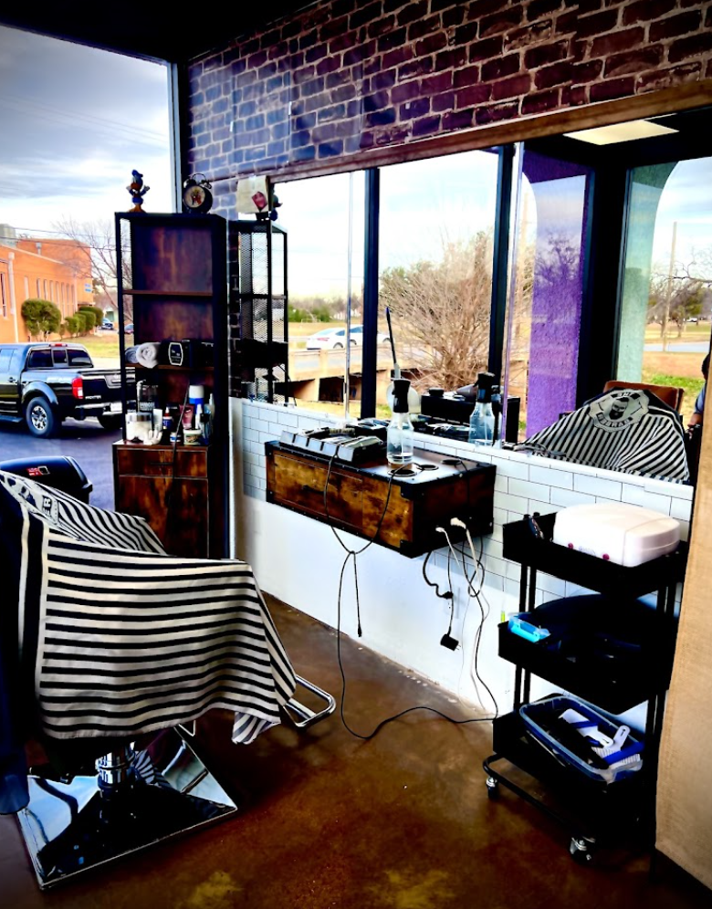 Claudia, owner and master barber of Claude's Barbershop in Abilene Texas, giving a precision fade haircut to a client in a traditional barber chair