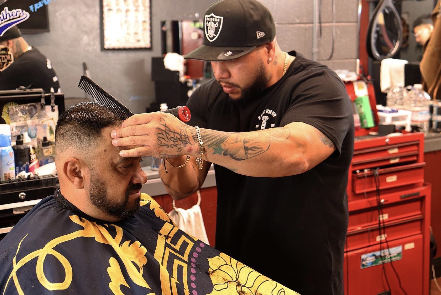 Master barber performing a precise straight razor beard trim on a client in a dimly lit, modern shop