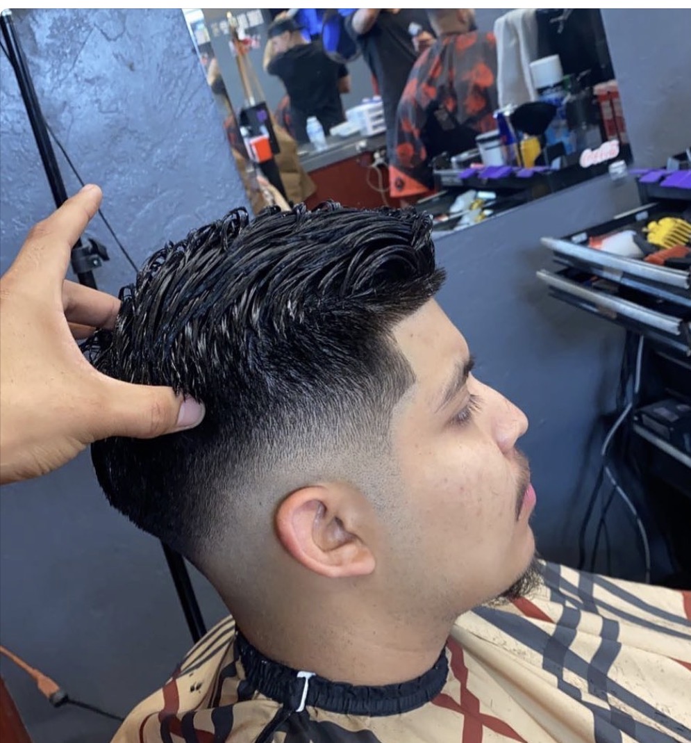 Happy client smiling, showing off a fresh, sharp skin fade and clean lineup