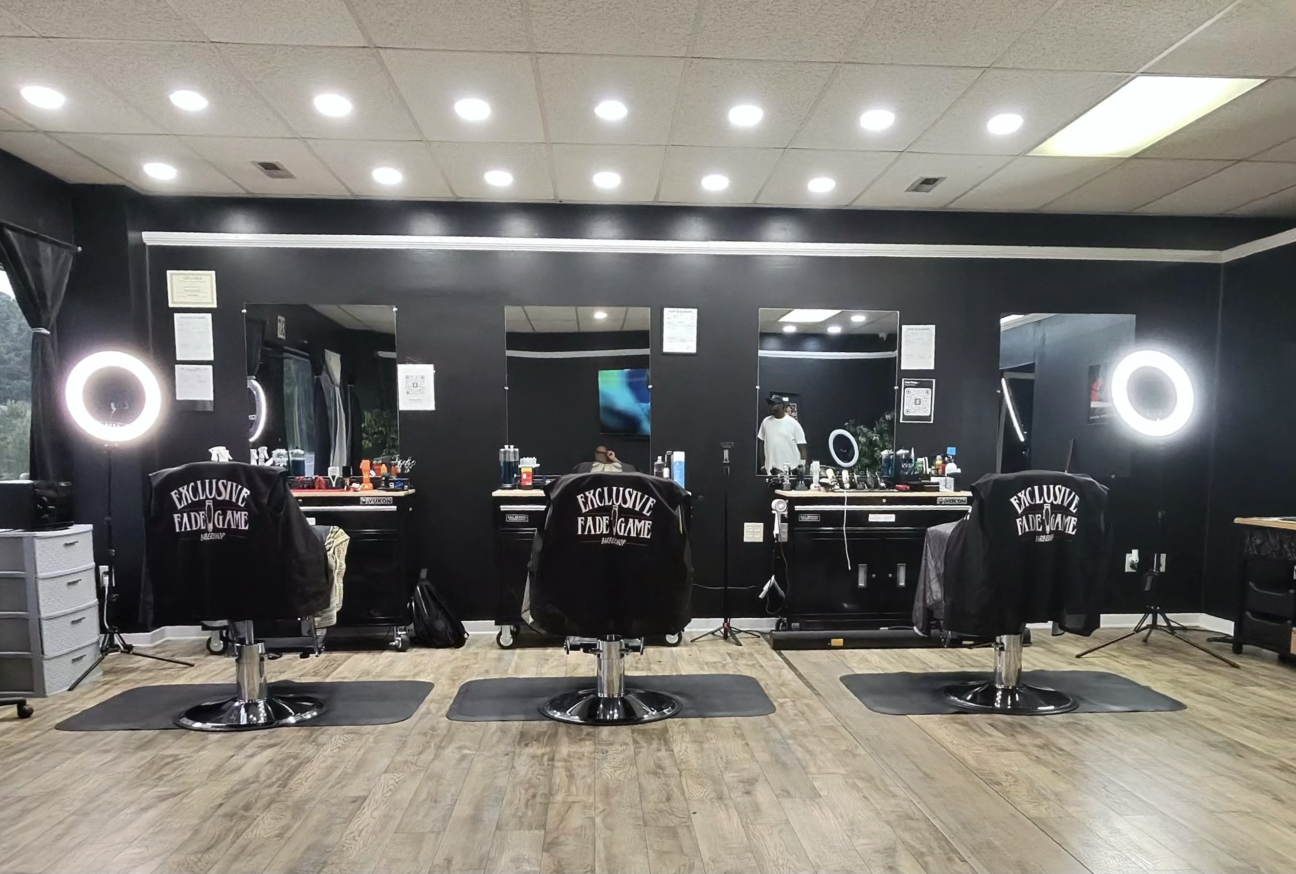 Interior of Exclusive Fade Game barbershop in Anniston Alabama with vintage barber chairs and framed wall art