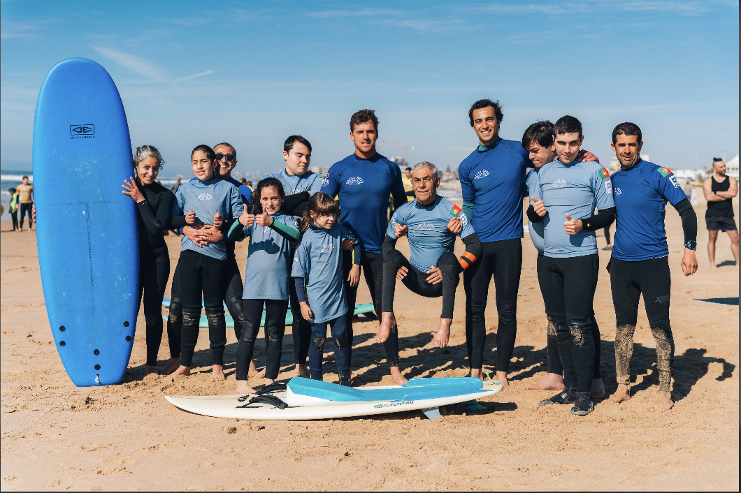 Os dois surfistas fundadores da Nossa Onda Surf Adaptado na praia de Carcavelos com pranchas, retrato documental autêntico