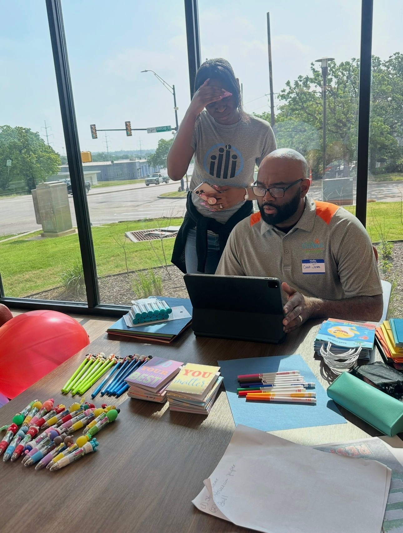Dedicated youth mentor guiding a teenage student through a homework session at community center